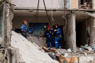 Ukrainian rescuers work among the rubble inside of a destroyed residential building at the site of an air attack in Kyiv on July 31, 2025